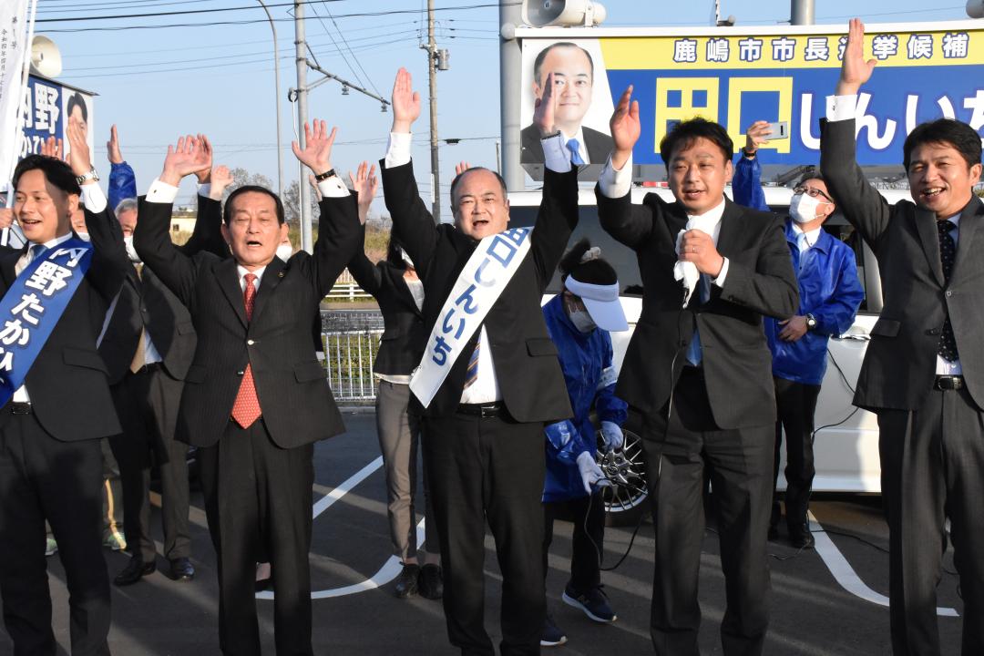 無投票で初当選が決まり、万歳する田口伸一氏(中央)=鹿嶋市宮中
