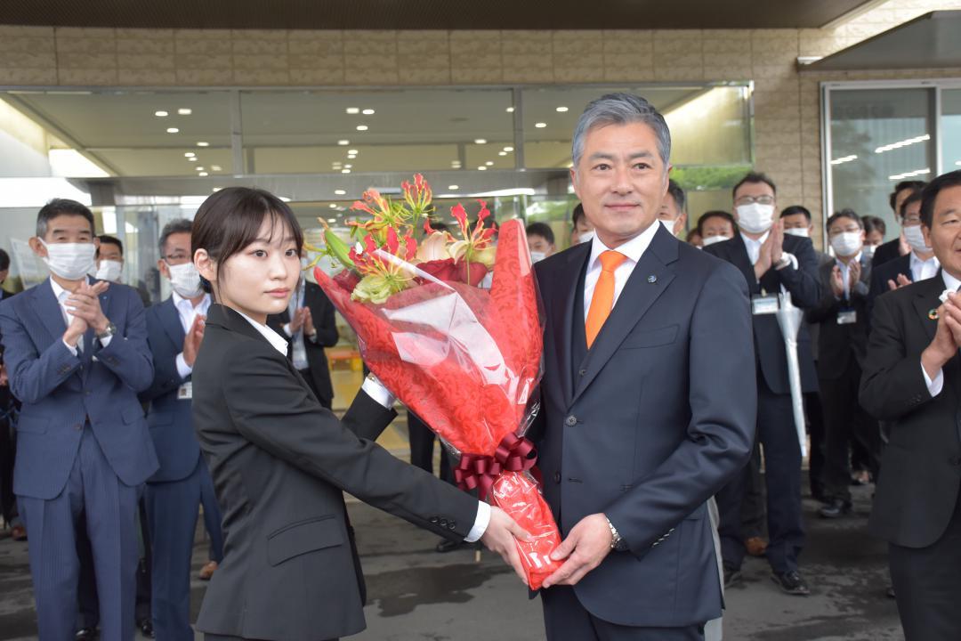 職員から花束を受け取る小田川浩市長(右)=つくばみらい市役所伊奈庁舎
