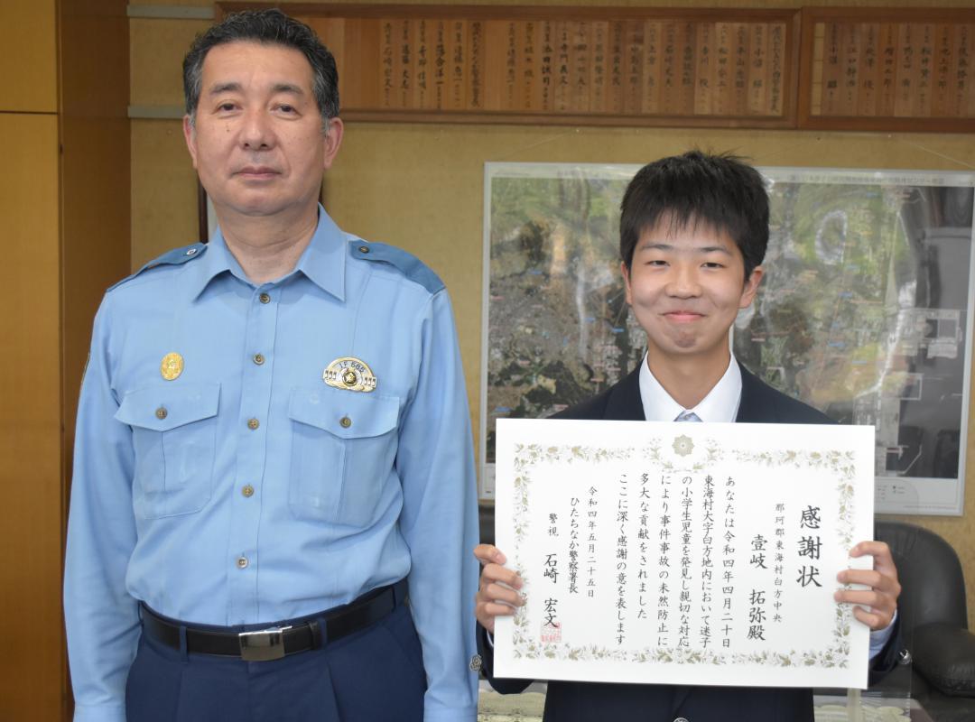 迷子の男児を保護し、石崎宏文署長から感謝状を贈られた壱岐拓弥さん(右)=ひたちなか警察署
