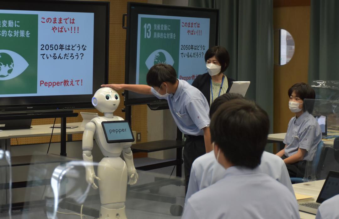 人型ロボット「ペッパー」に触れる生徒=茨城町奥谷
