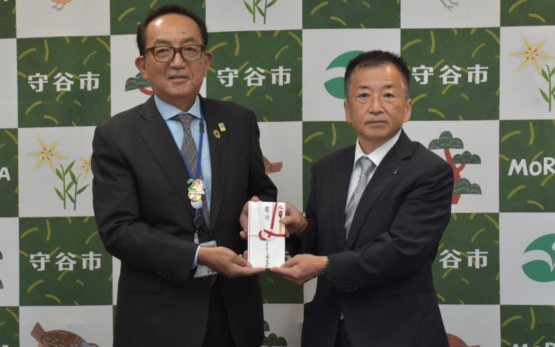 寄付金を手渡す今泉暢智統括工場長(右)=守谷市役所
