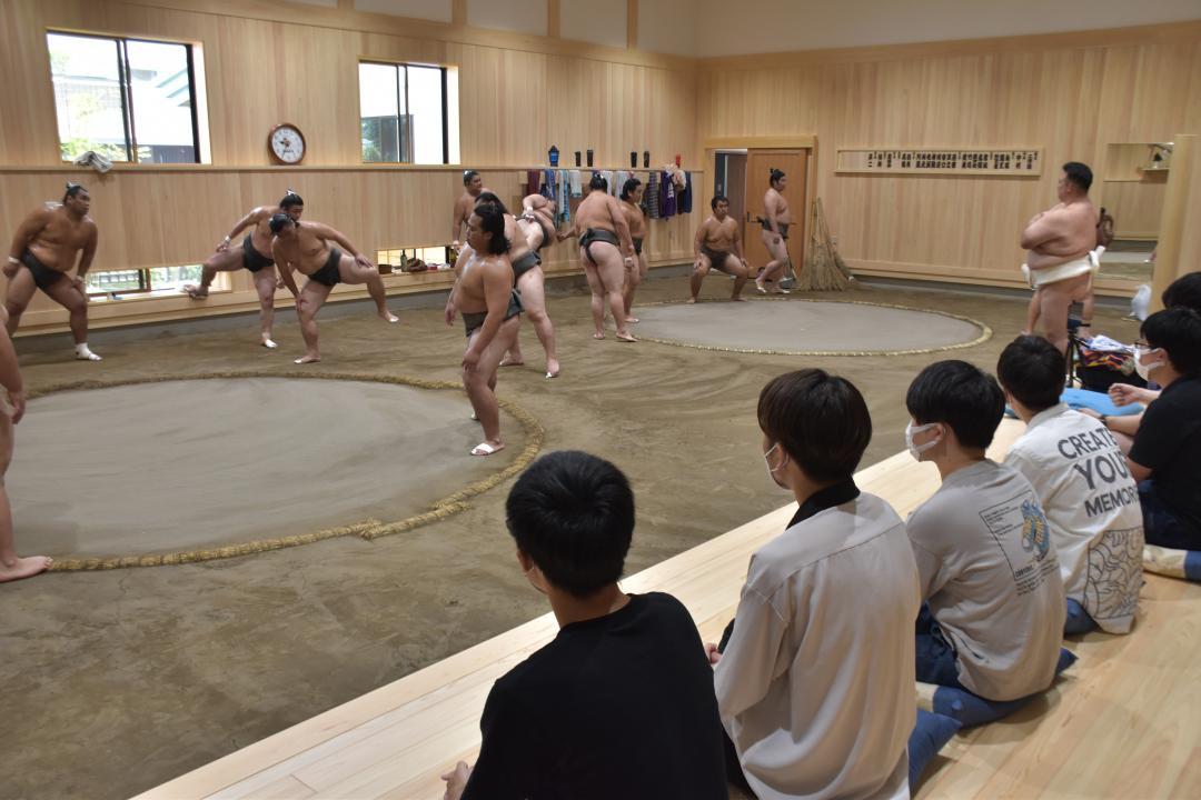 土俵を2面使った稽古を見学する学生=阿見町荒川本郷