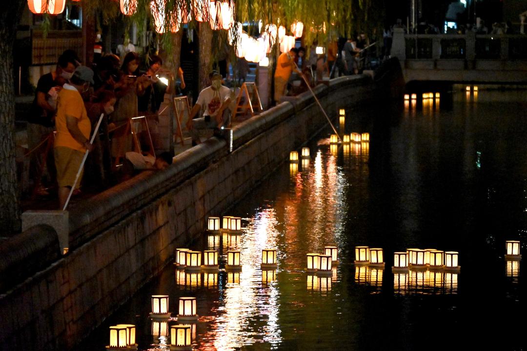先祖の霊を供養する灯籠流しの明かりが備前堀の水面に映える＝水戸市紺屋町
