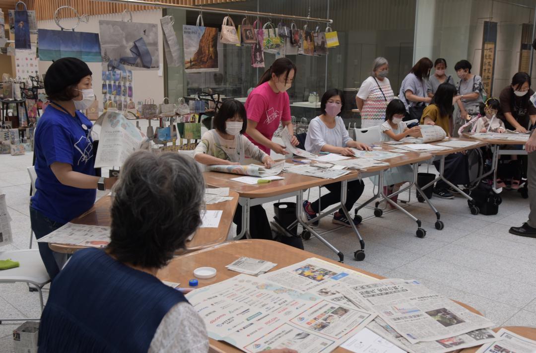 新聞ばっぐ作りを体験する来場者たち=笠間市南友部
