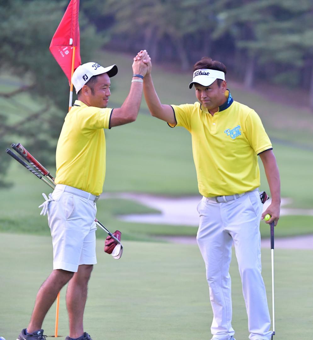 プレーオフ3ホール目で決着し、初優勝を喜び合う平岡和彦(左)・篠内博司組=宍戸ヒルズCC