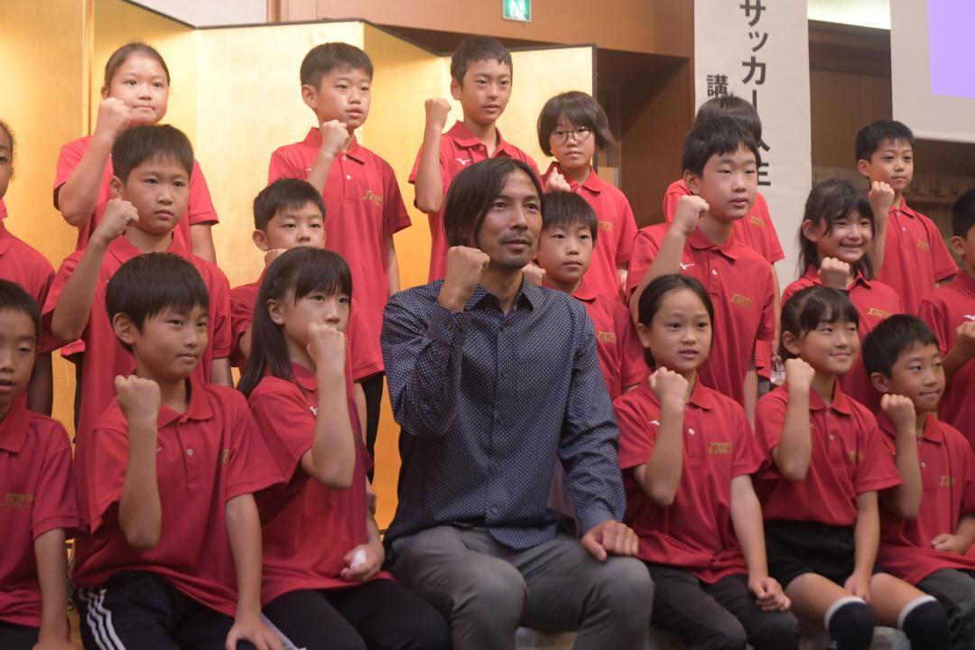 元サッカー日本代表の鈴木隆行さん(1列目中央)と記念撮影する3期生=水戸市内

