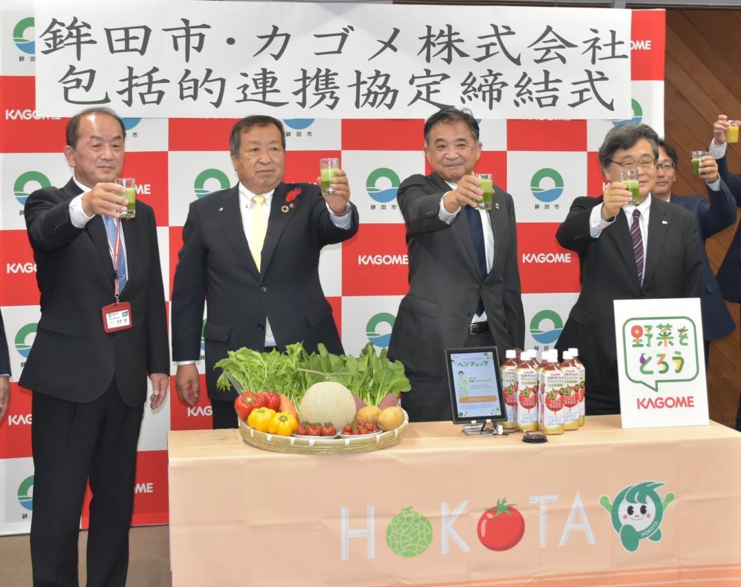 協定を結び野菜のスムージーで乾杯する鉾田市の岸田一夫市長(左から2人目)とカゴメの橋本隆取締役専務執行役員(同3人目)=同市役所

