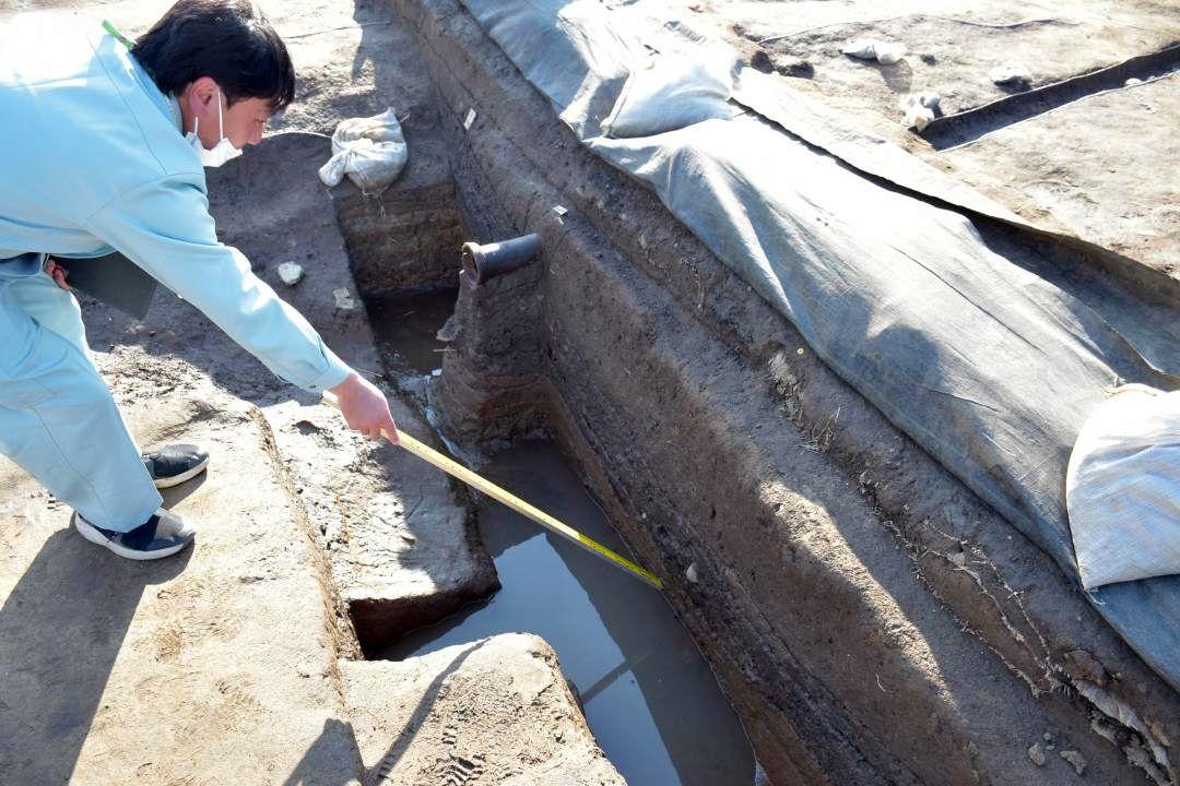 2つの池底の存在を示す地層について説明する調査員=桜川市真壁町古城
