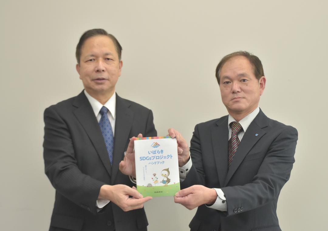冊子を森作宜民教育長(左)に手渡す茨城新聞社の沼田安広社長=県庁