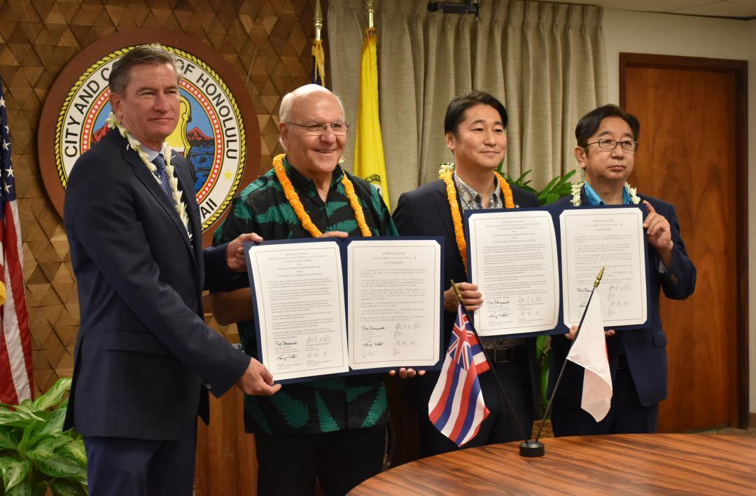 姉妹都市協定を締結した橋本正裕町長(中央右)とリック・ブランジャルディ市長(中央左)=ホノルル市役所
