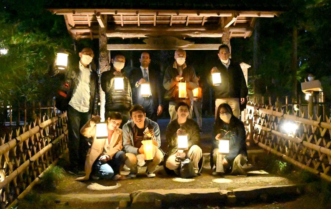 偕楽園で水府提灯ツアーを楽しむファムプログラムの参加者たち=同市常磐町