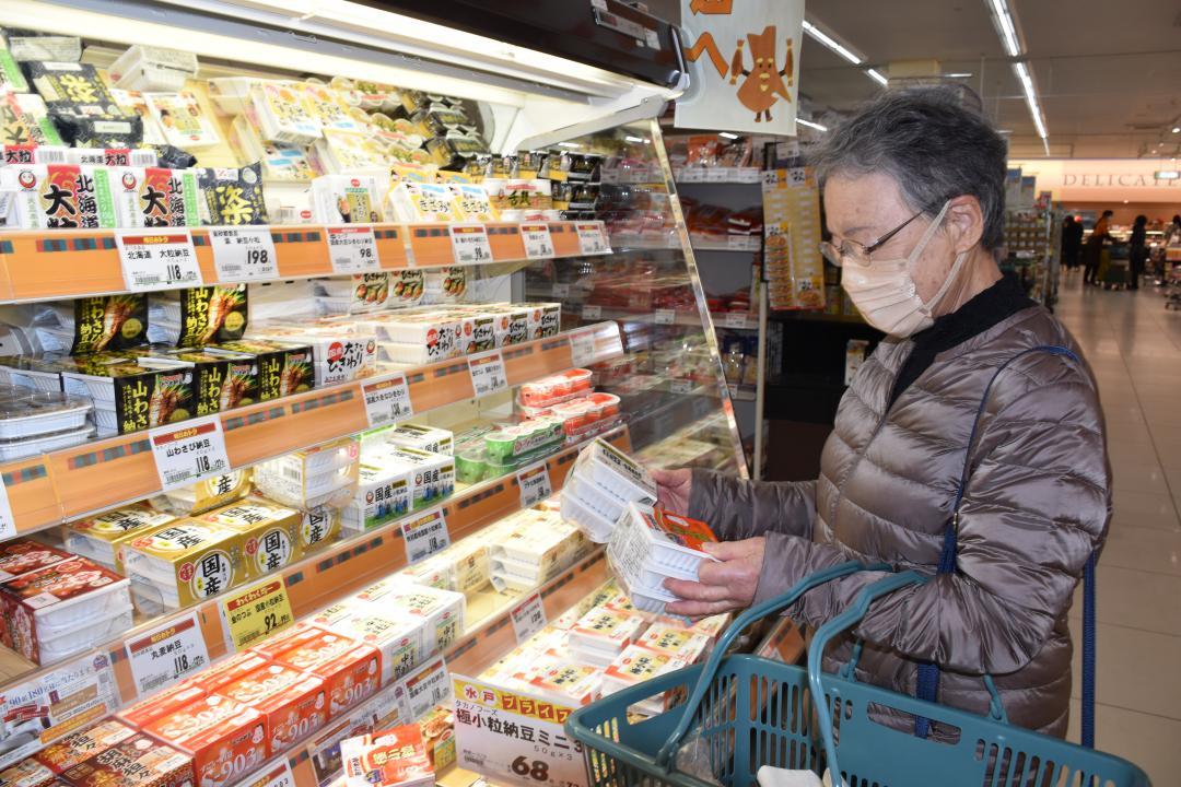多くの食品が値上がりする中、価格や内容量を確かめる買い物客=水戸市内のスーパー
