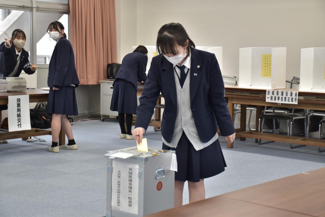 校内の臨時期日前投票所で1票を投じる生徒=常陸太田市栄町

