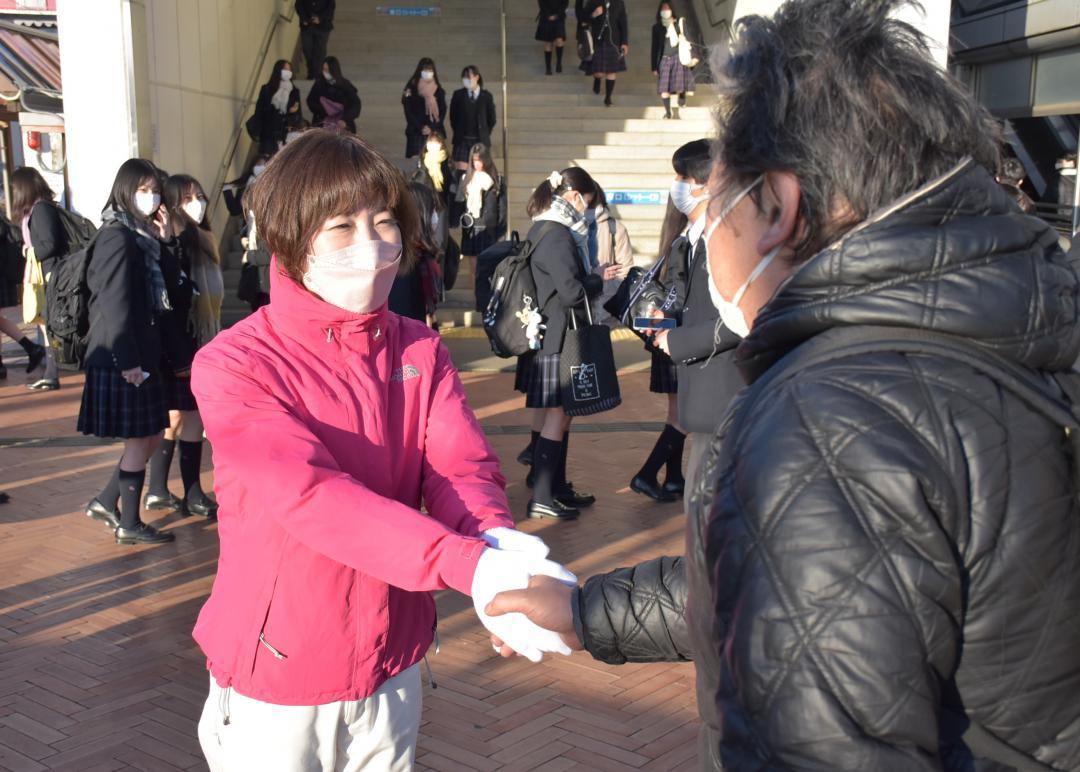 駅立ちで市民と握手を交わす長田麻美氏(左)=12日朝、JR牛久駅東口
