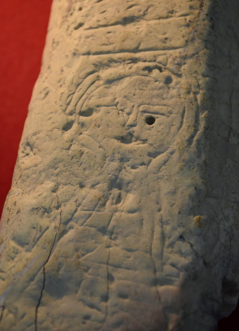下大賀遺跡から出土した石製支脚の正面に彫られた人物画
