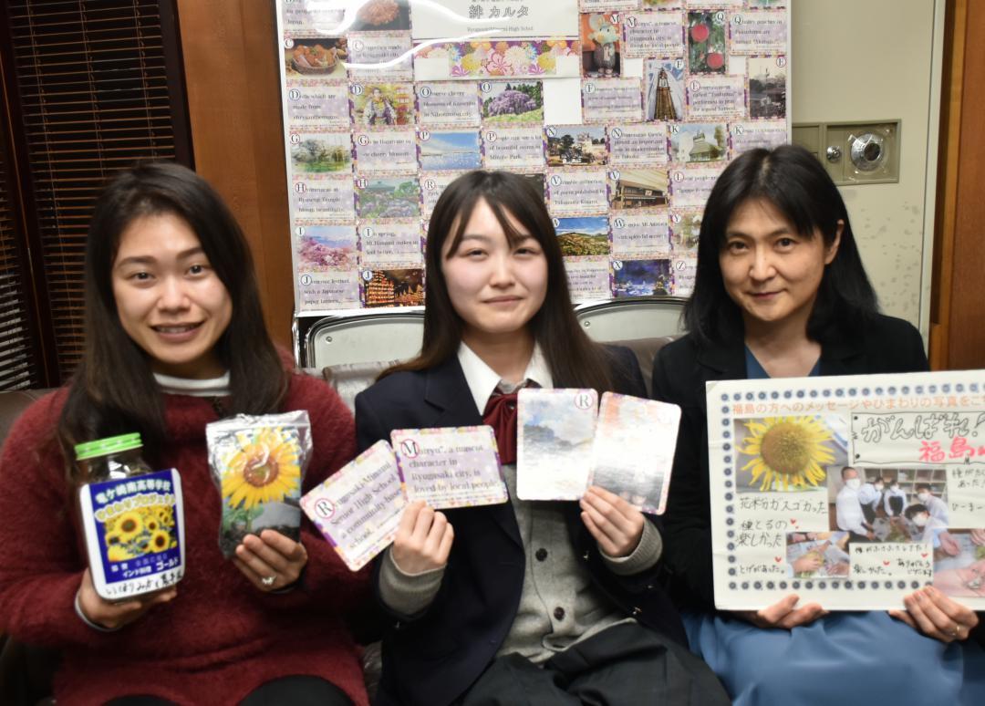 プロジェクト協力への感謝を込めた「絆カルタ」を紹介する関野鈴華さん(中央)=竜ケ崎南高