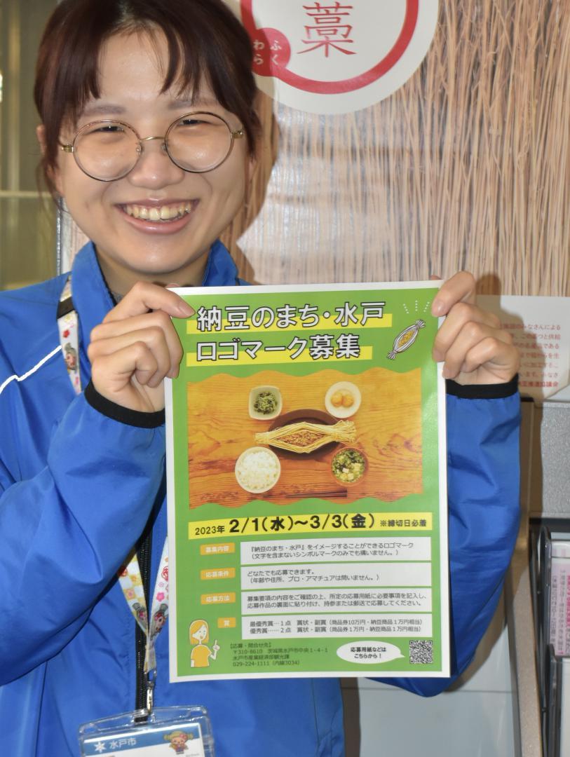 「納豆のまち・水戸　ロゴマーク募集」を呼びかけるチラシを掲げる水戸市観光課職員=同市中央
