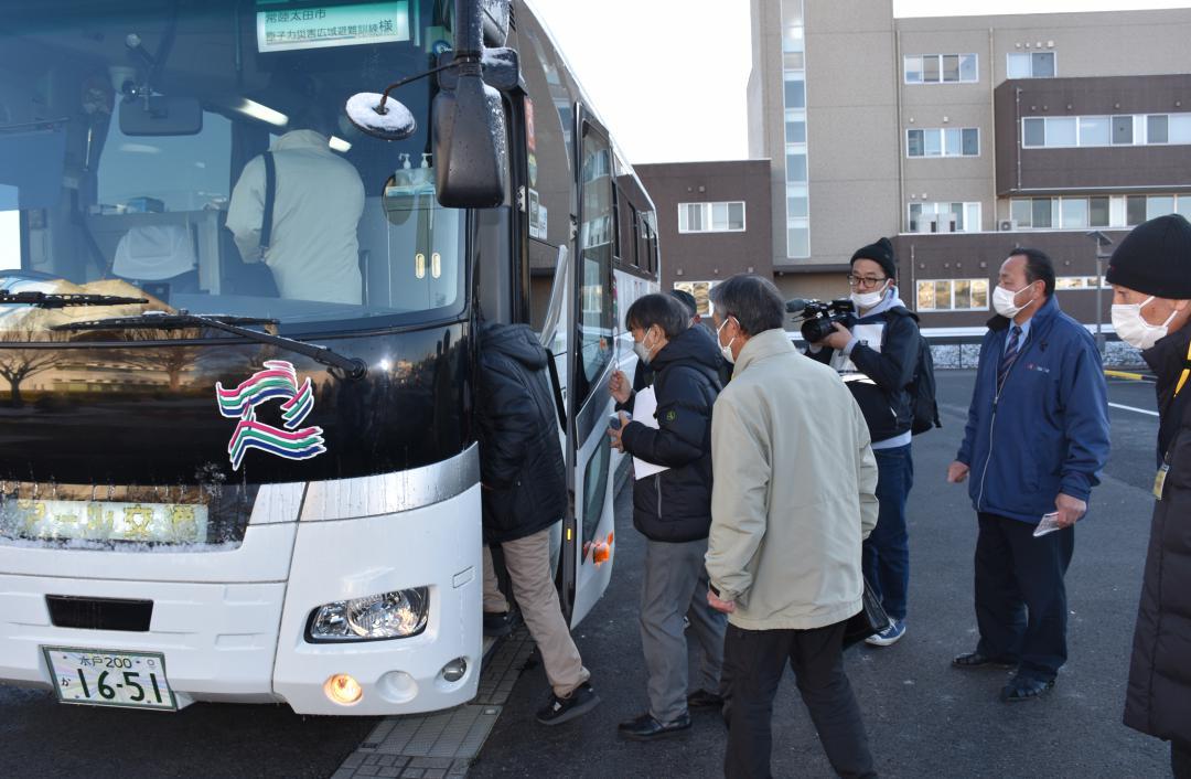 避難先の福島県会津美里町へ向かうバスに乗り込む住民ら=常陸太田市役所駐車場
