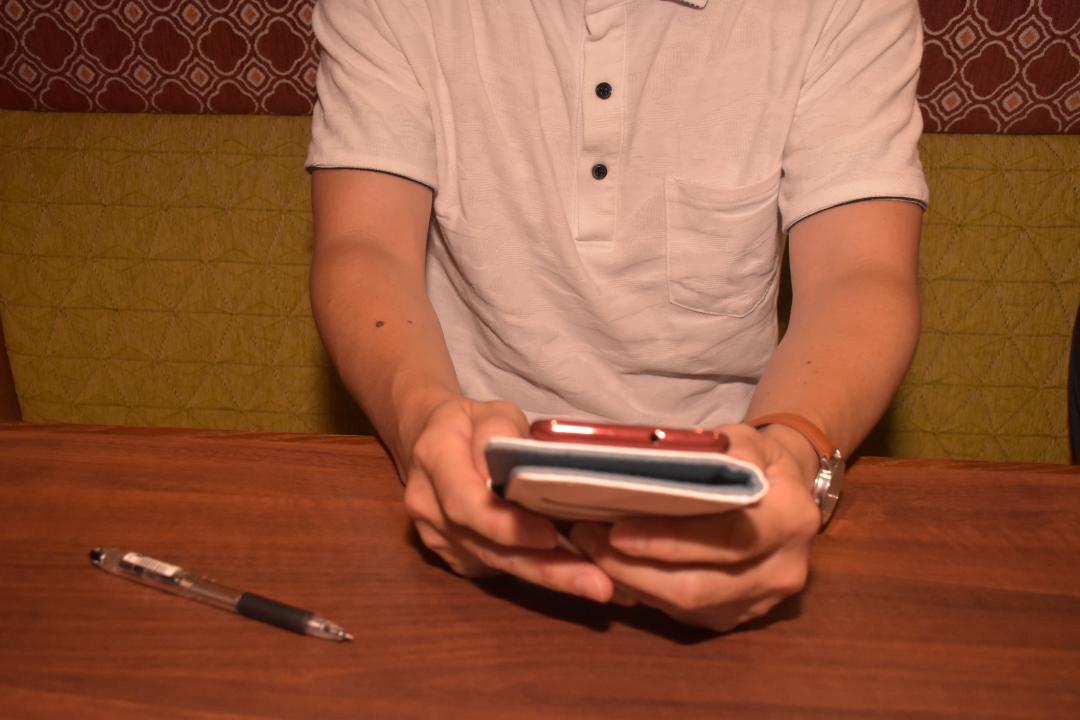 ひきこもりから「脱出」し、仕事の予定をスマートフォンで確認するマサテルさん(仮名)=つくば市内