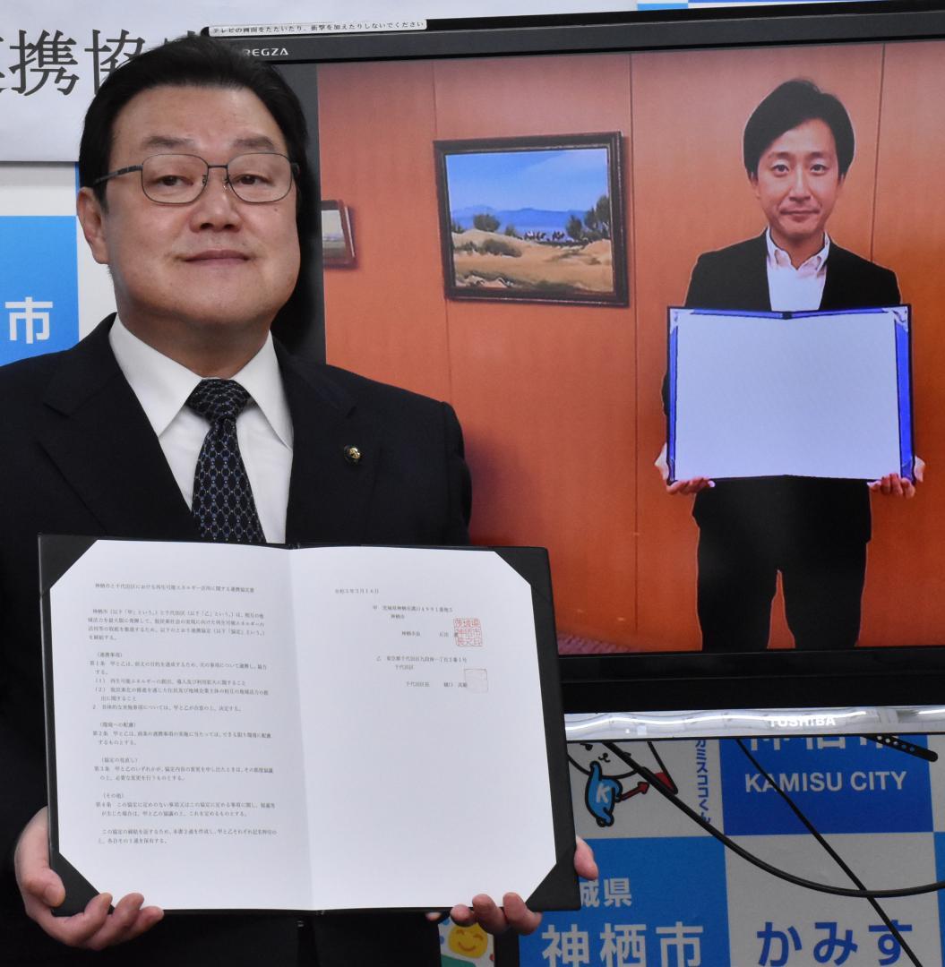 オンラインで互いに協定書を見せ合う、石田進市長(左)と樋口高顕区長=神栖市溝口
