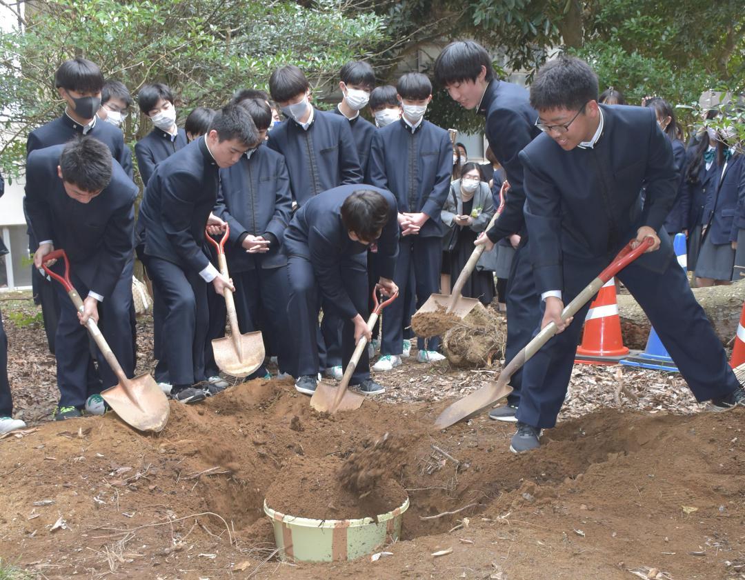 15年後に開封するタイムカプセルを埋める清真学園中の卒業生たち=鹿嶋市宮中
