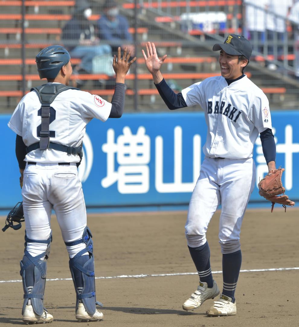茨城-下妻二　完投勝利し、捕手粕谷とハイタッチする茨城・佐藤由(右)=ノーブルホーム水戸
