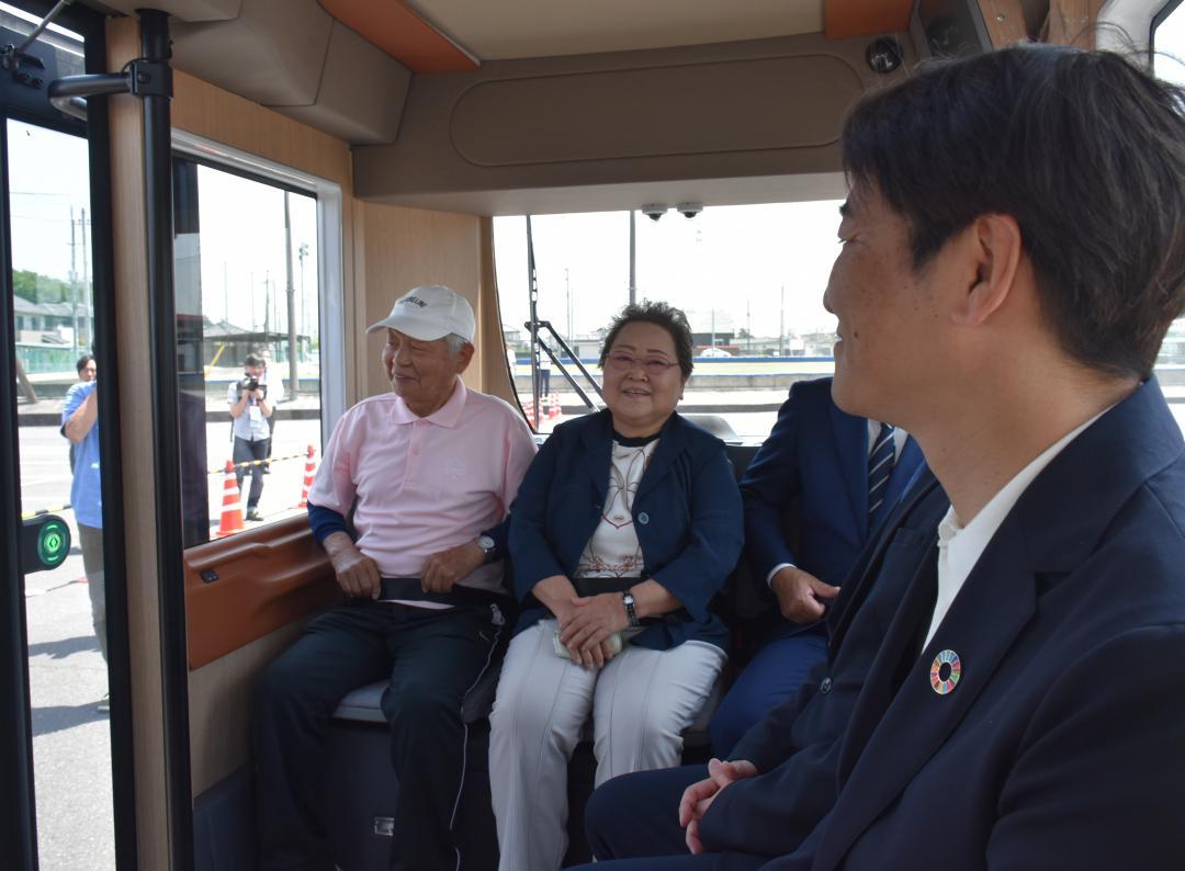橋本正裕町長(右)と自動運転バスに試乗し笑顔を見せる住民=境町上小橋
