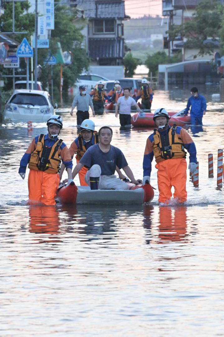 大雨の影響により浸水した住宅地で、ボートで救助される住民たち=3日午後6時44分、取手市双葉