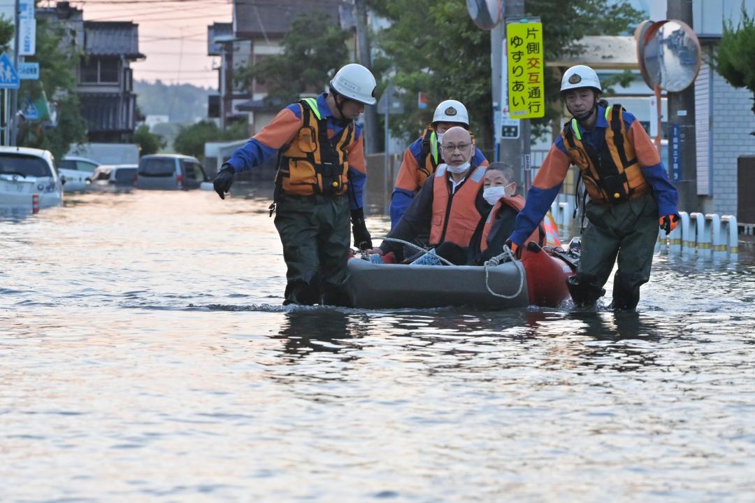 浸水した住宅地でボートで救助される住民=3日午後6時47分、取手市双葉