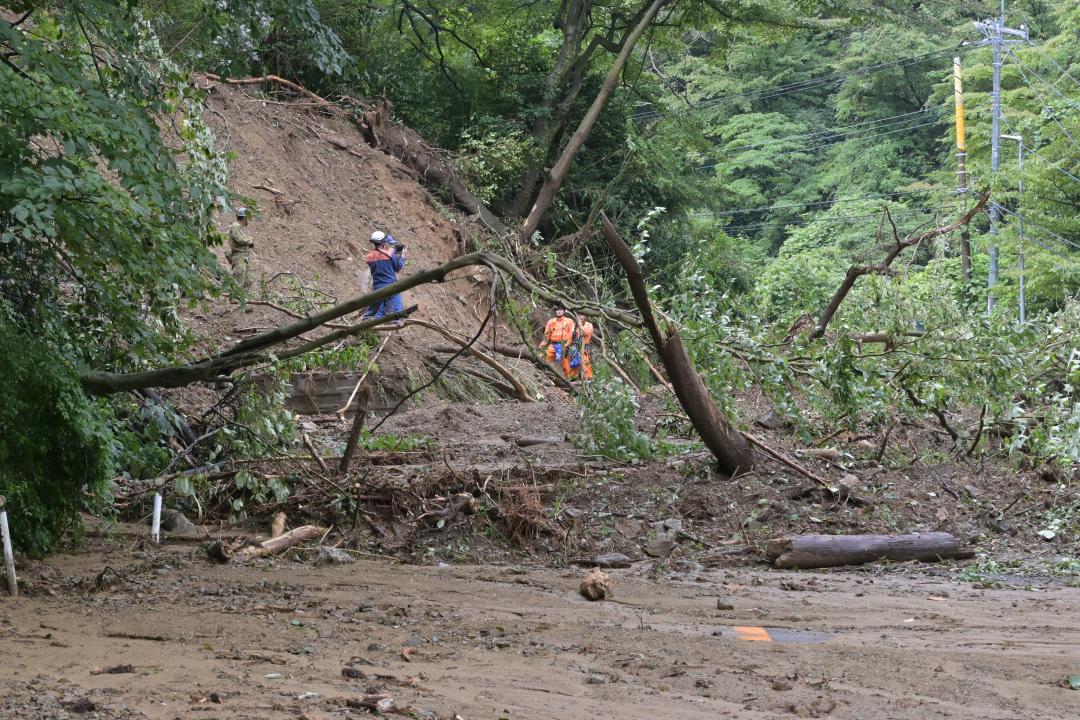 土砂崩れが起きた県道日立山方線で検索活動する日立市消防職員ら9日=午前10時20分ごろ、同市宮田町