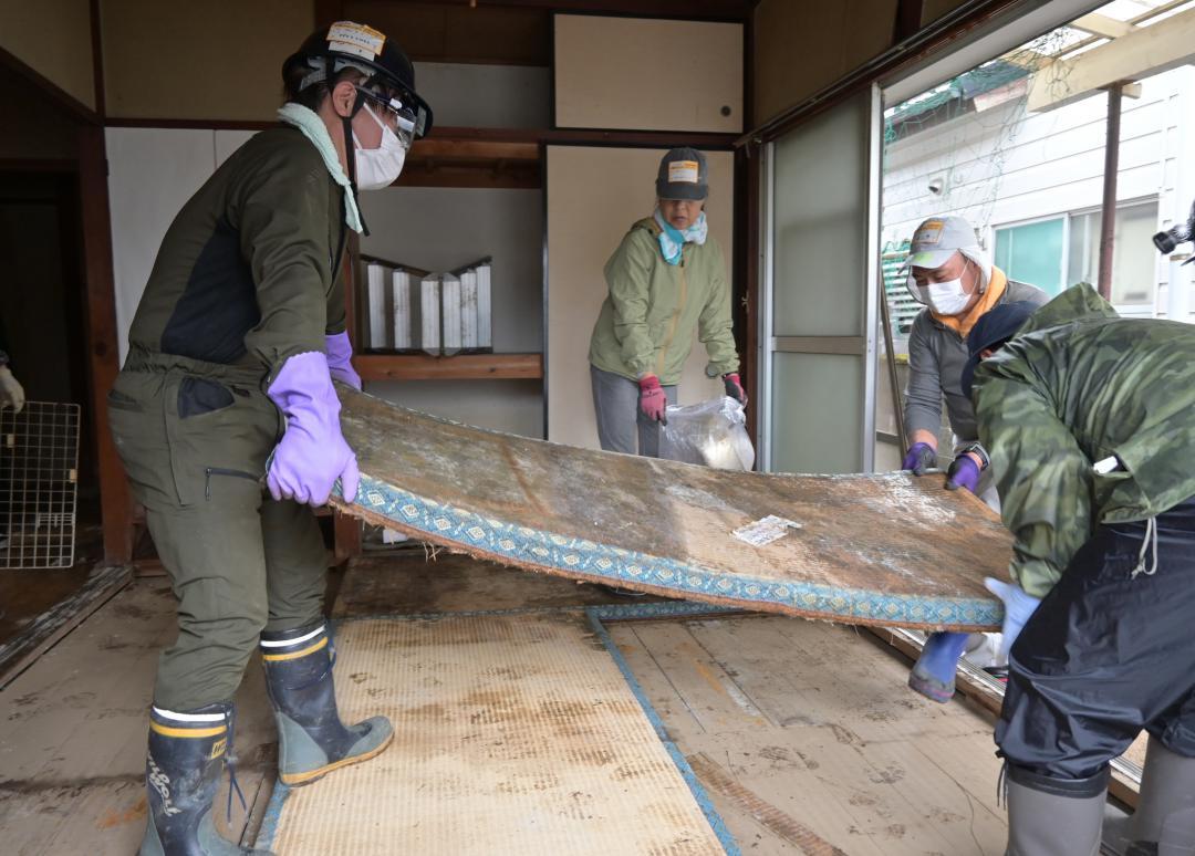 浸水した家屋の畳を片付けるボランティア=北茨城市大津町
