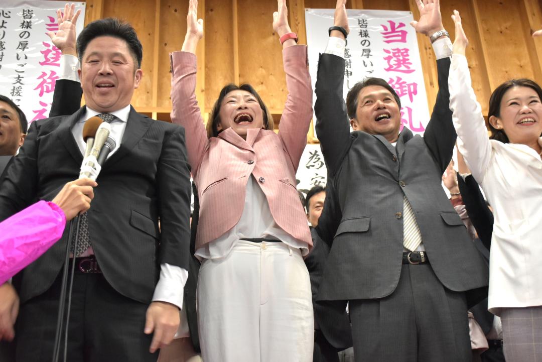 土浦市長選で再選を決め、万歳して喜ぶ安藤真理子氏(左から2人目)=22日午後8時5分ごろ、同市下高津の選挙事務所