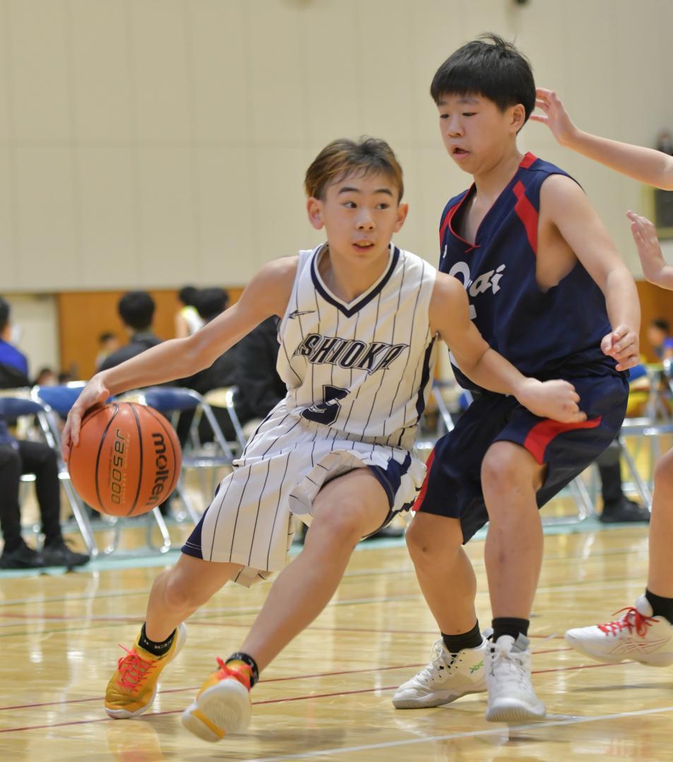 〈男子1回戦〉石岡KID少年団-大洗スポ少　第2クオーター、鋭いドリブルで切り込む石岡KID少年団の田上蓮稀(左)=水戸市総合運動公園体育館
