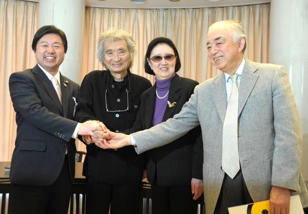 水戸芸術館の新館長就任会見で、高橋靖水戸市長、森英恵さん、吉田光男副館長と握手を交わす小澤征爾さん(左から2人目)=2013年4月4日、水戸芸術館