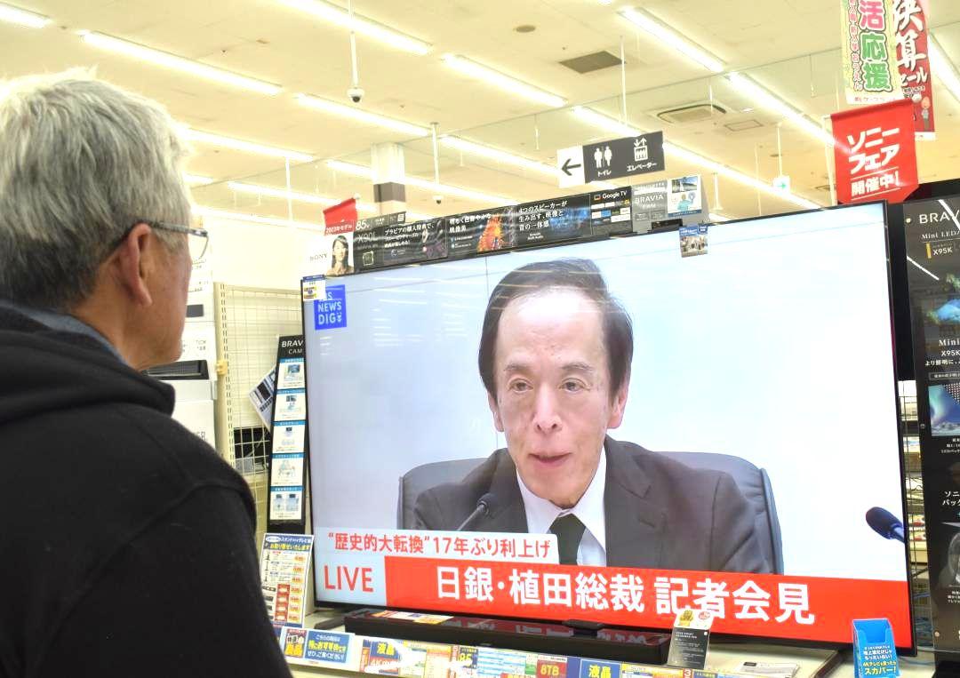 日銀・植田和男総裁の会見をテレビで見る買い物客=水戸市内の家電量販店
