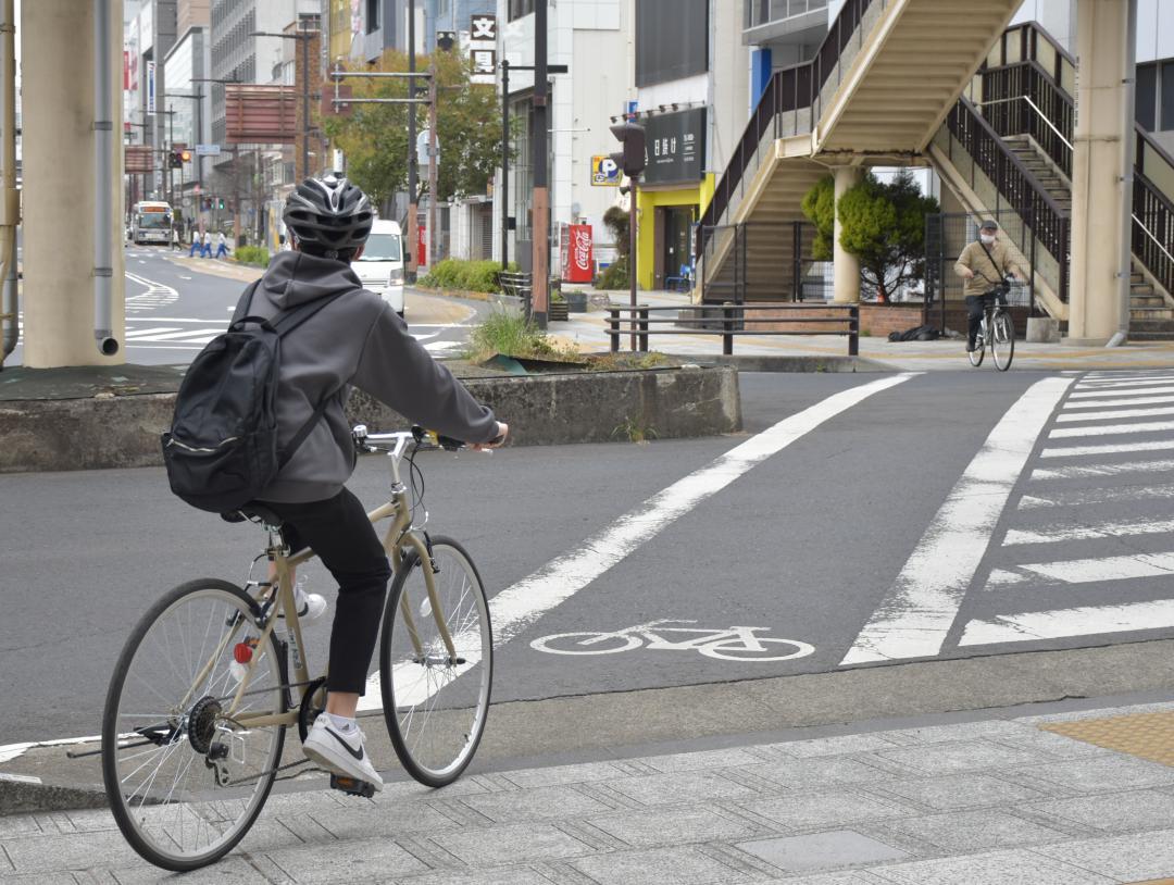 ヘルメットを着用し、自転車で街中を走る学生=茨城県水戸市三の丸

