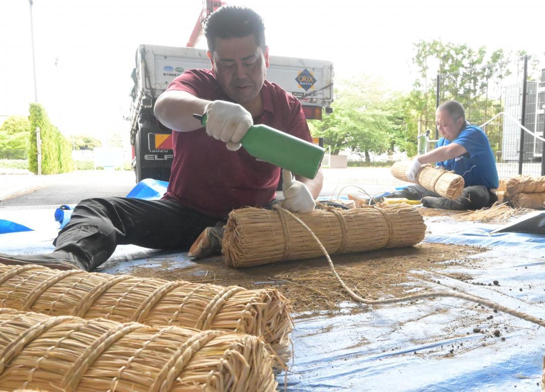 稲わらで編んだ俵に土を詰め、形を整える呼び出しの禄郎さん(左)と重太郎さん=水戸市緑町
