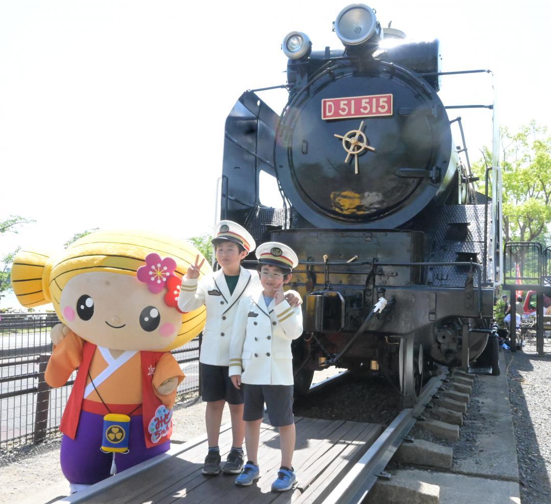 蒸気機関車D51の前で駅長になり切って記念撮影を楽しむ子どもたち=水戸市千波町
