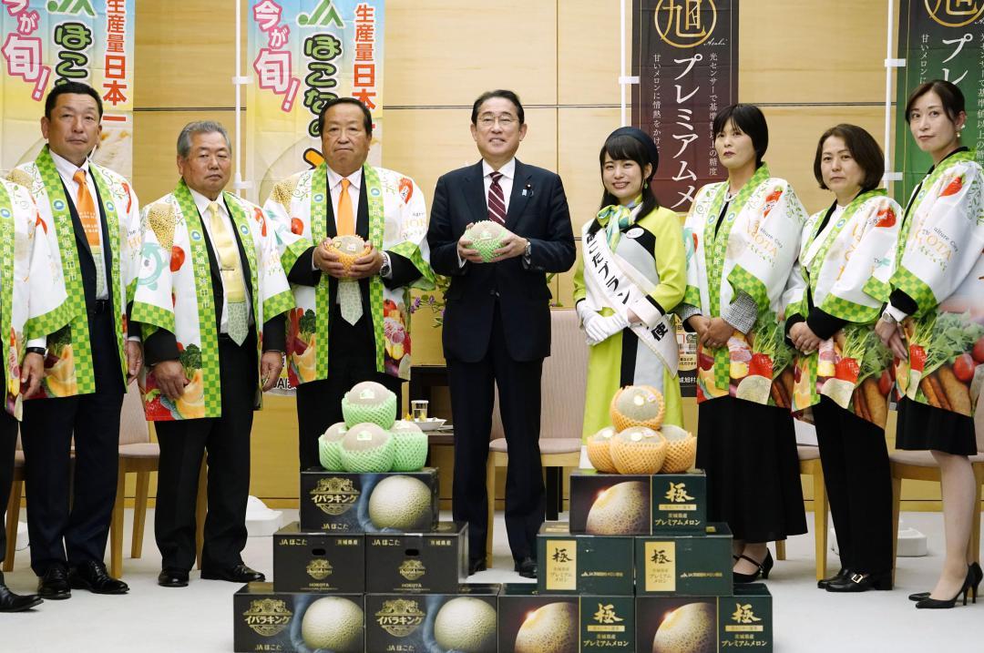 鉾田市の岸田一夫市長(左から3人目)らからメロンを贈られた岸田首相(同4人目)=8日午後、首相官邸
