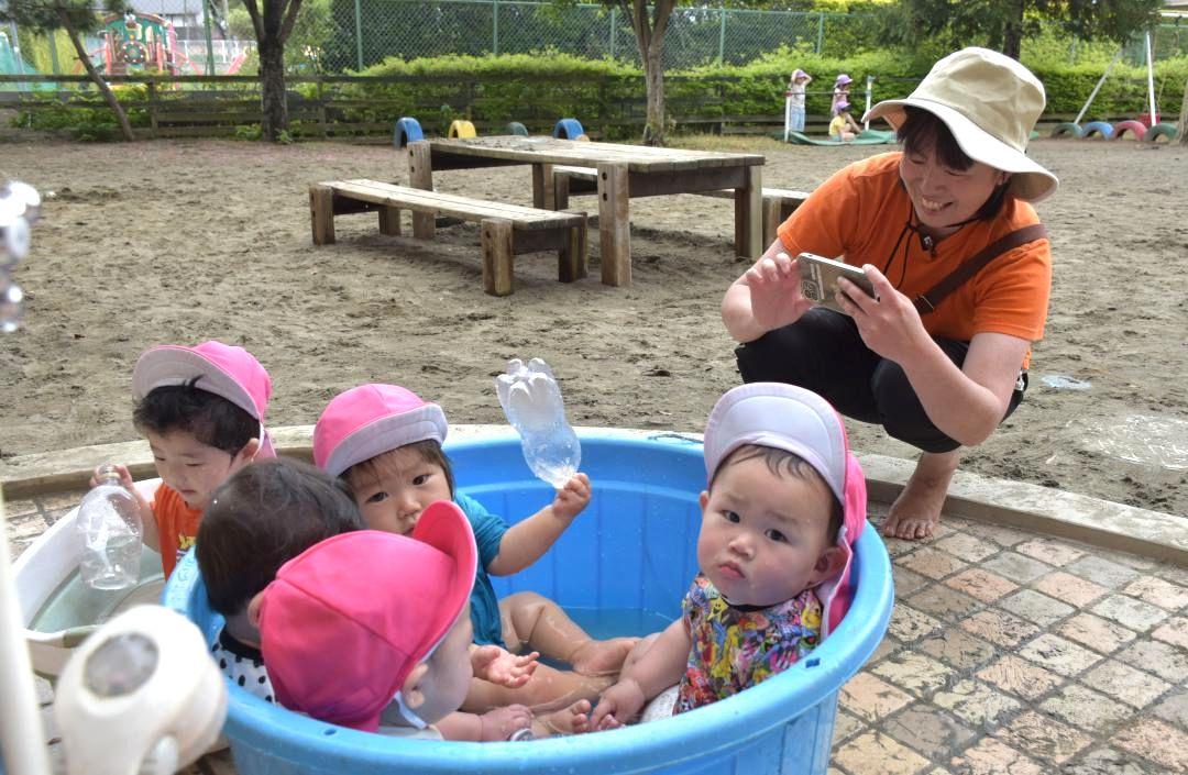 スマートフォンで園児の様子を撮影する保育士=守谷市本町のまつやま保育園
