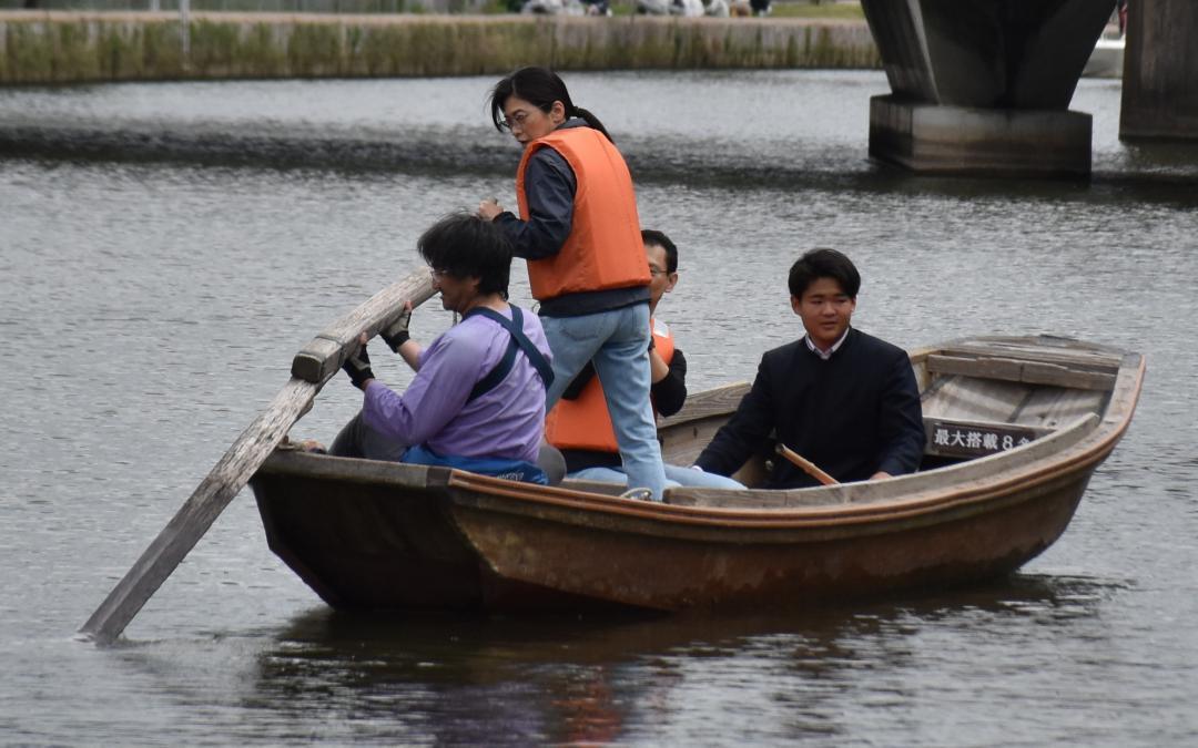 清真学園高生が企画したイベントで、ろ舟の操作を体験する参加者=潮来市の前川
