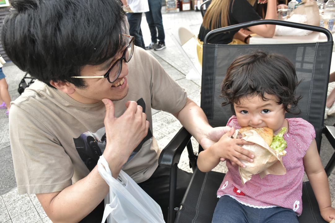 イベントで佐世保バーガーを食べる親子=つくば市吾妻
