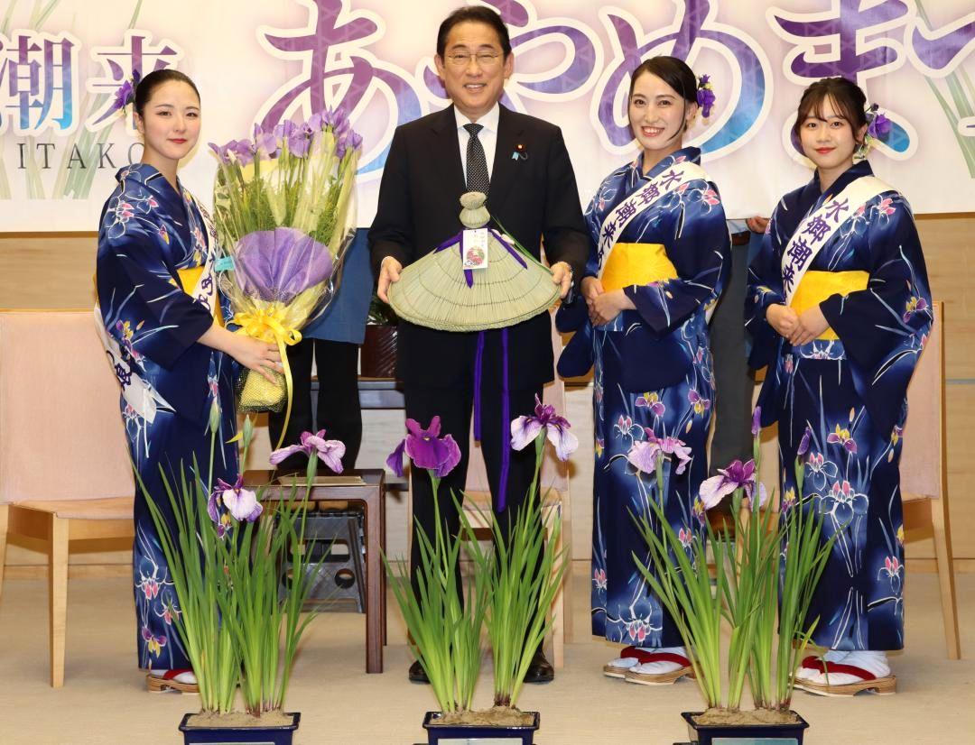 潮来市の「あやめ娘」から贈呈された笠を手にする岸田文雄首相=首相官邸
