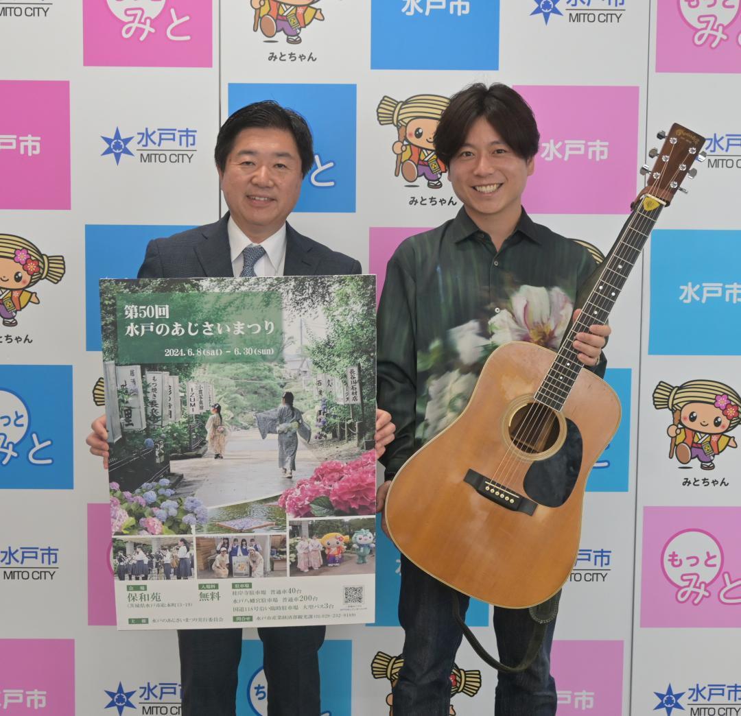 水戸のあじさいまつりのテーマソング完成を高橋靖市長(左)に報告した磯山純さん=水戸市役所
