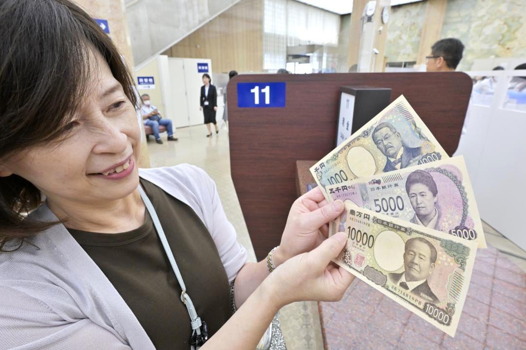 受け取った新紙幣を見る女性=3日午後、水戸市南町の常陽銀行本店

