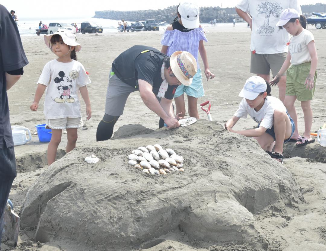 砂を成形し、マンボウを作る参加者たち=鹿嶋市平井
