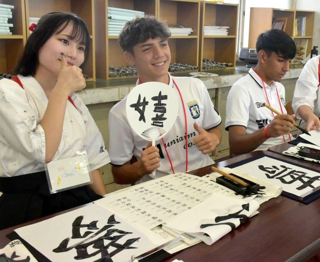 書道で交流するマドリード州選抜選手と波崎高校の生徒=神栖市土合本町
