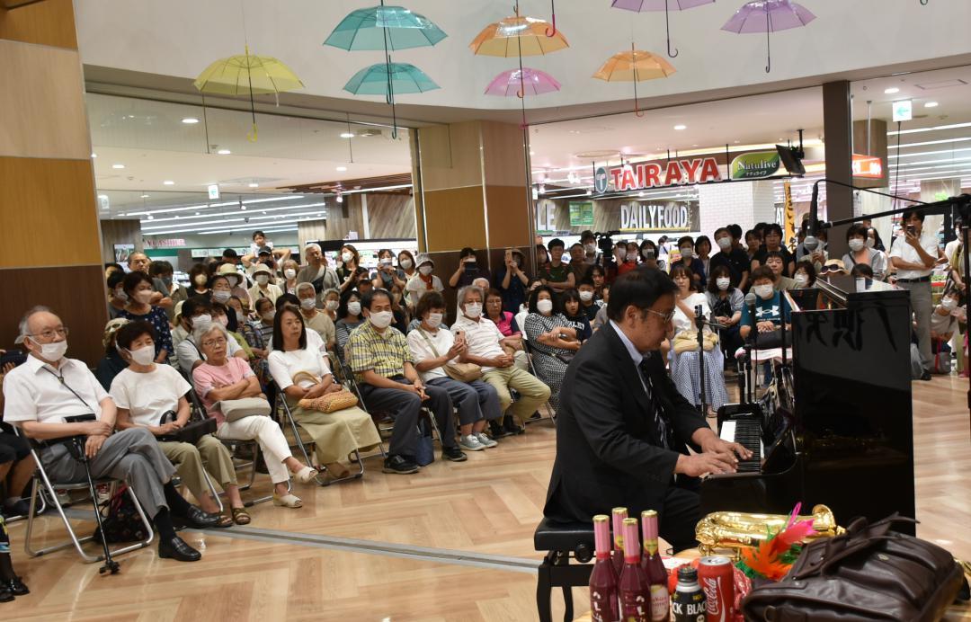 ピアノ演奏を披露する「カンパネラおじさん」として知られる徳永義昭さん(右)=古河市雷電町
