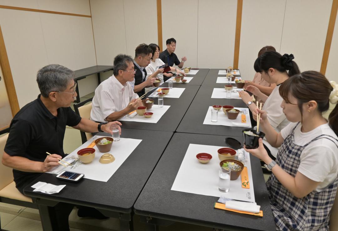 「HITACHI目光あんかけ丼」を試食する関係者ら=日立市十王町伊師
