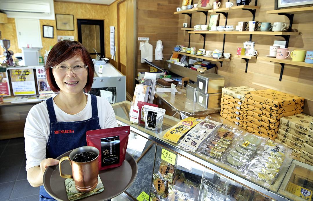 せんべいも並ぶ山王珈琲焙煎所。厳選したコーヒー豆を提供する同店代表の椎名浩子さん=取手市山王
